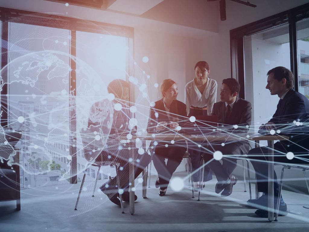 Global Delivery Centers and Resource Augmentation services image group of people at a conference desk with overlay of globe
