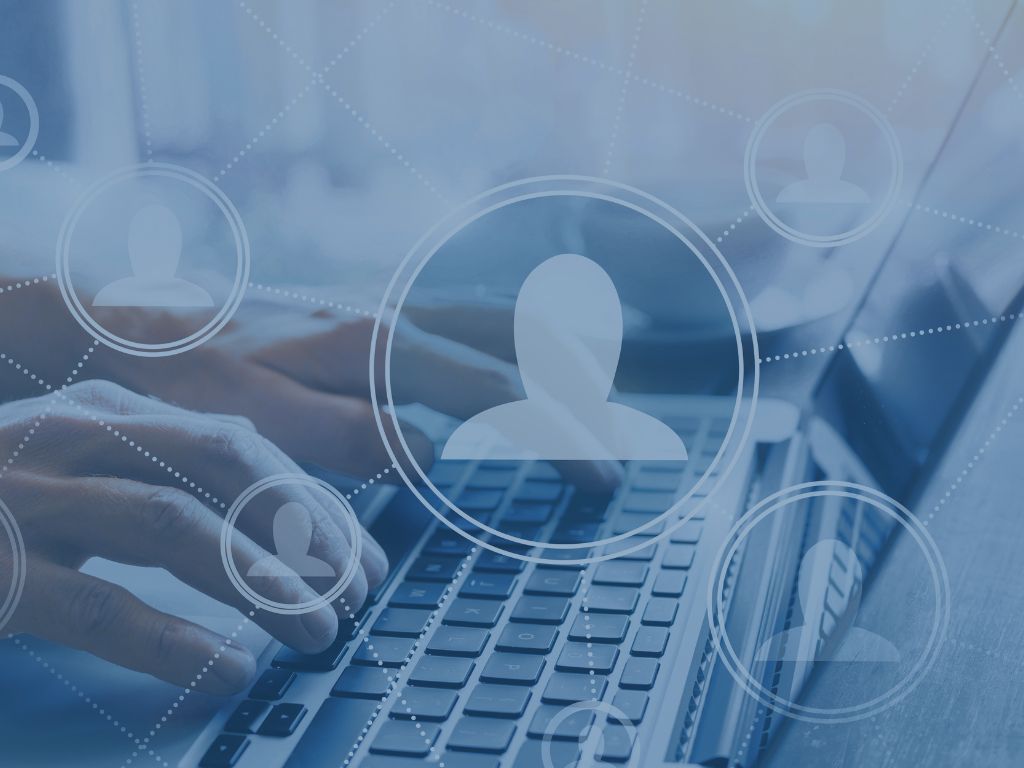 Staffing image of person icons with hands on laptop and tech overlay